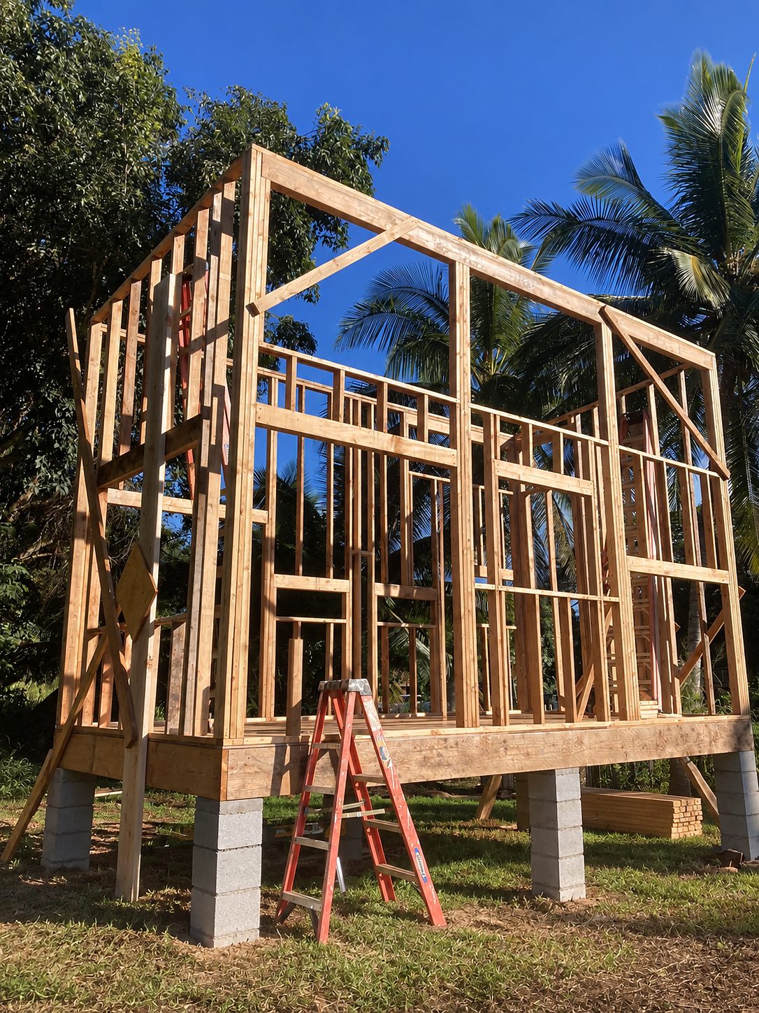 Small structure on concrete piers with a shed roof, framed in lumber under a blue sky