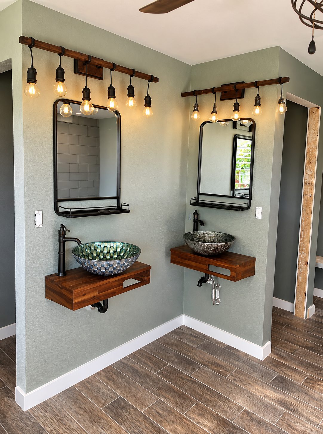 Double vanity with two vessel sinks on live-edge floating wood counters against sage walls