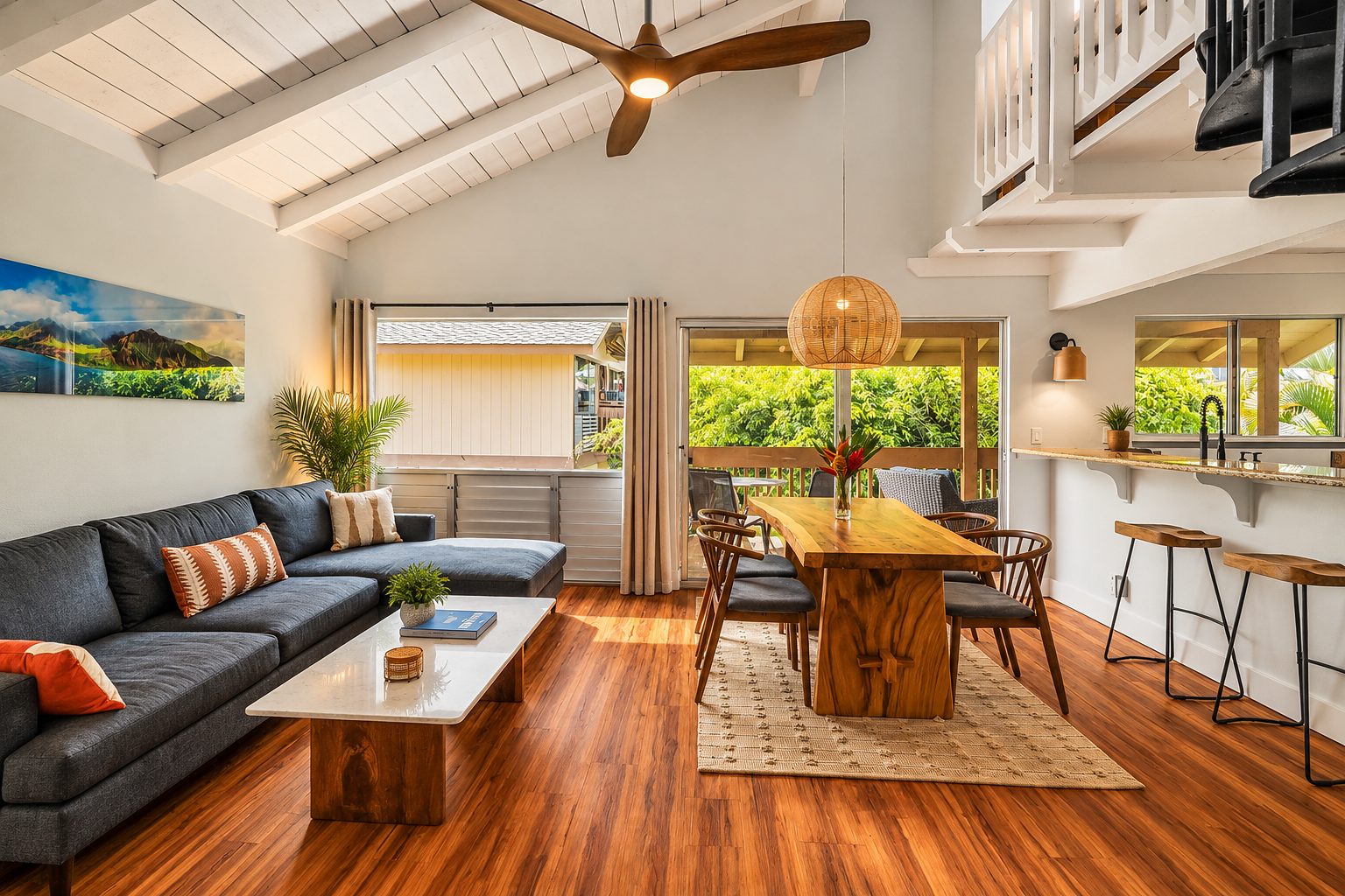Remodeled condo living room with a vaulted white ceiling, exposed beams and the kitchen beyond
