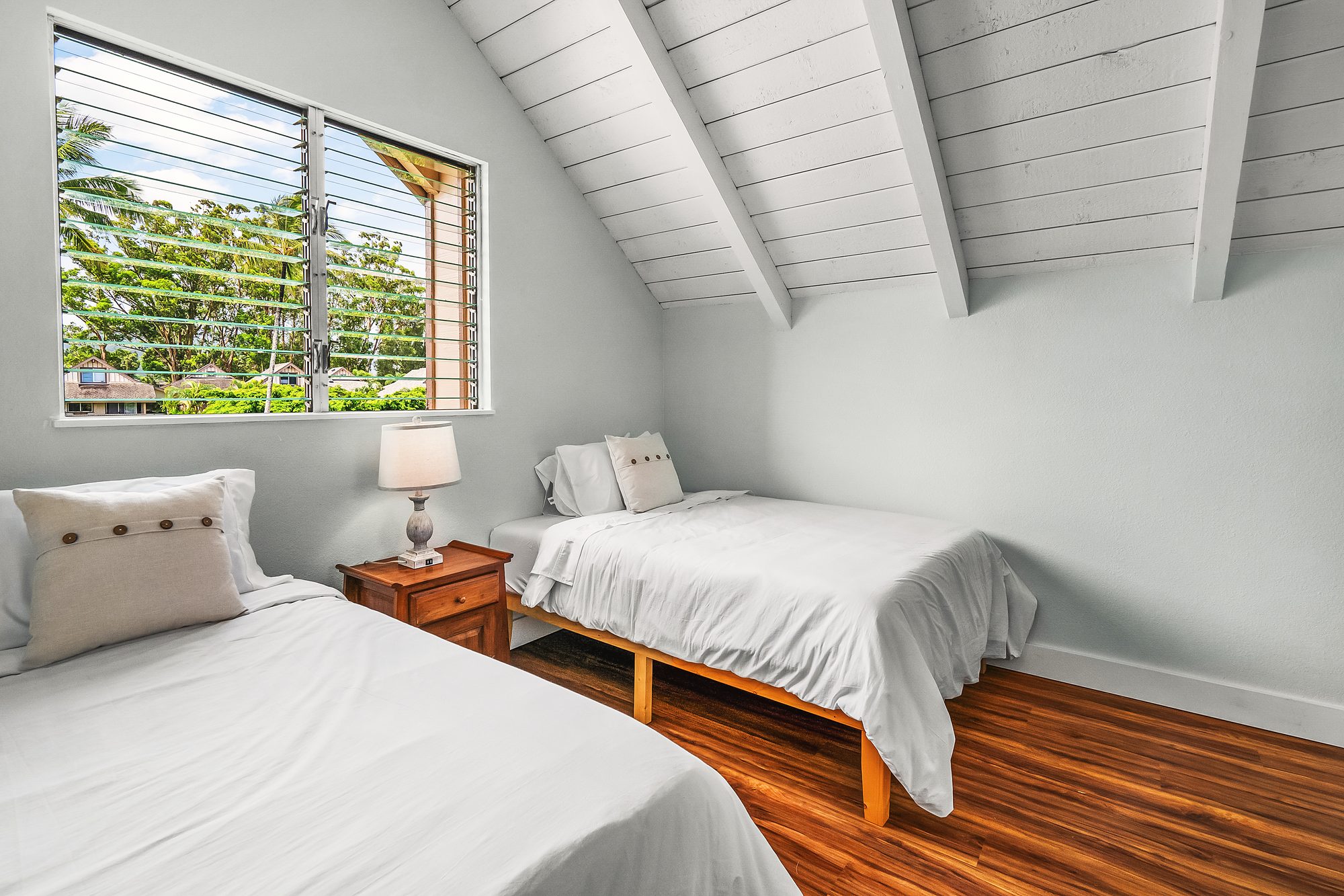 Sleeping loft under the ridge with twin beds and a window to the trees
