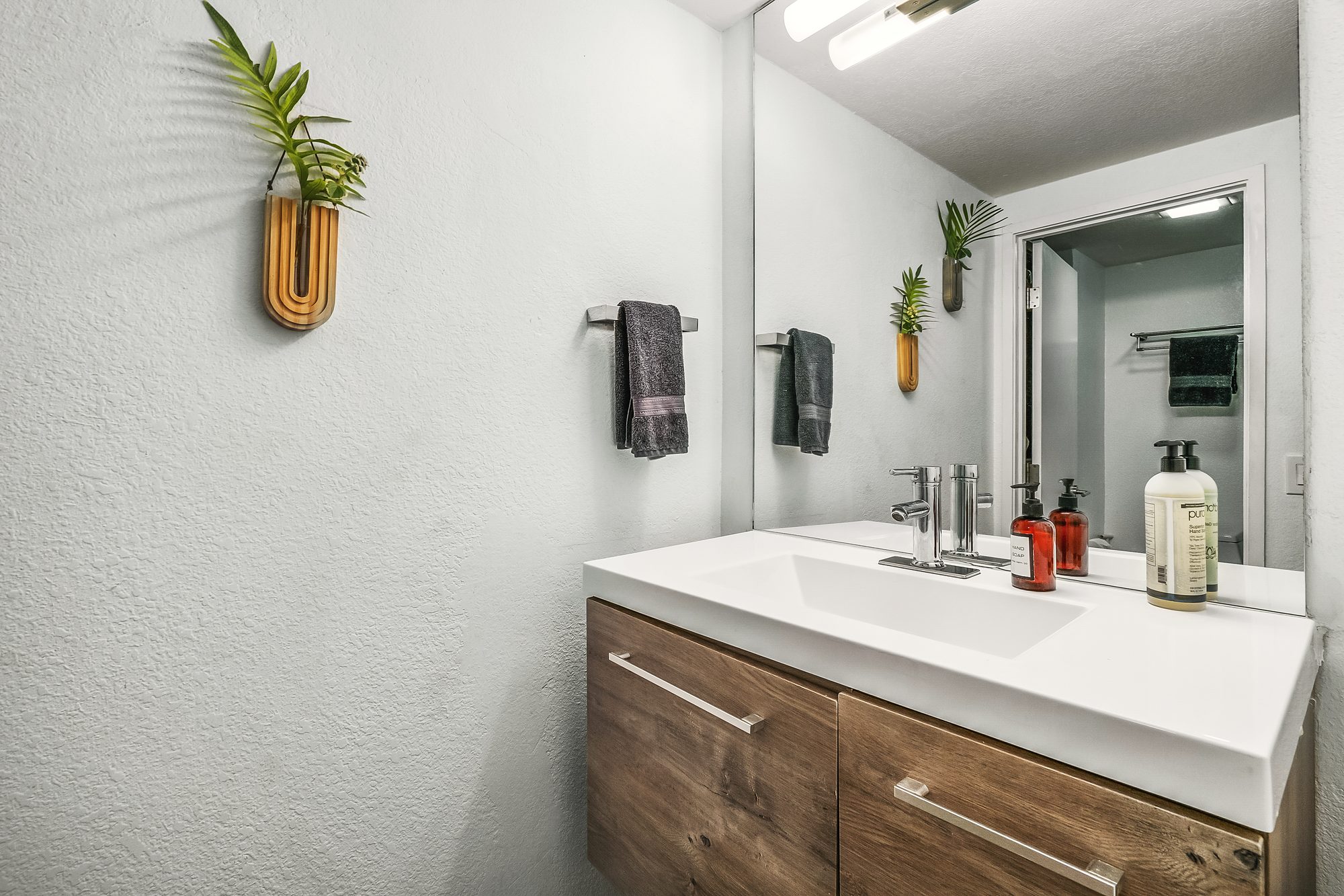 Bathroom vanity with a white counter and a walnut cabinet