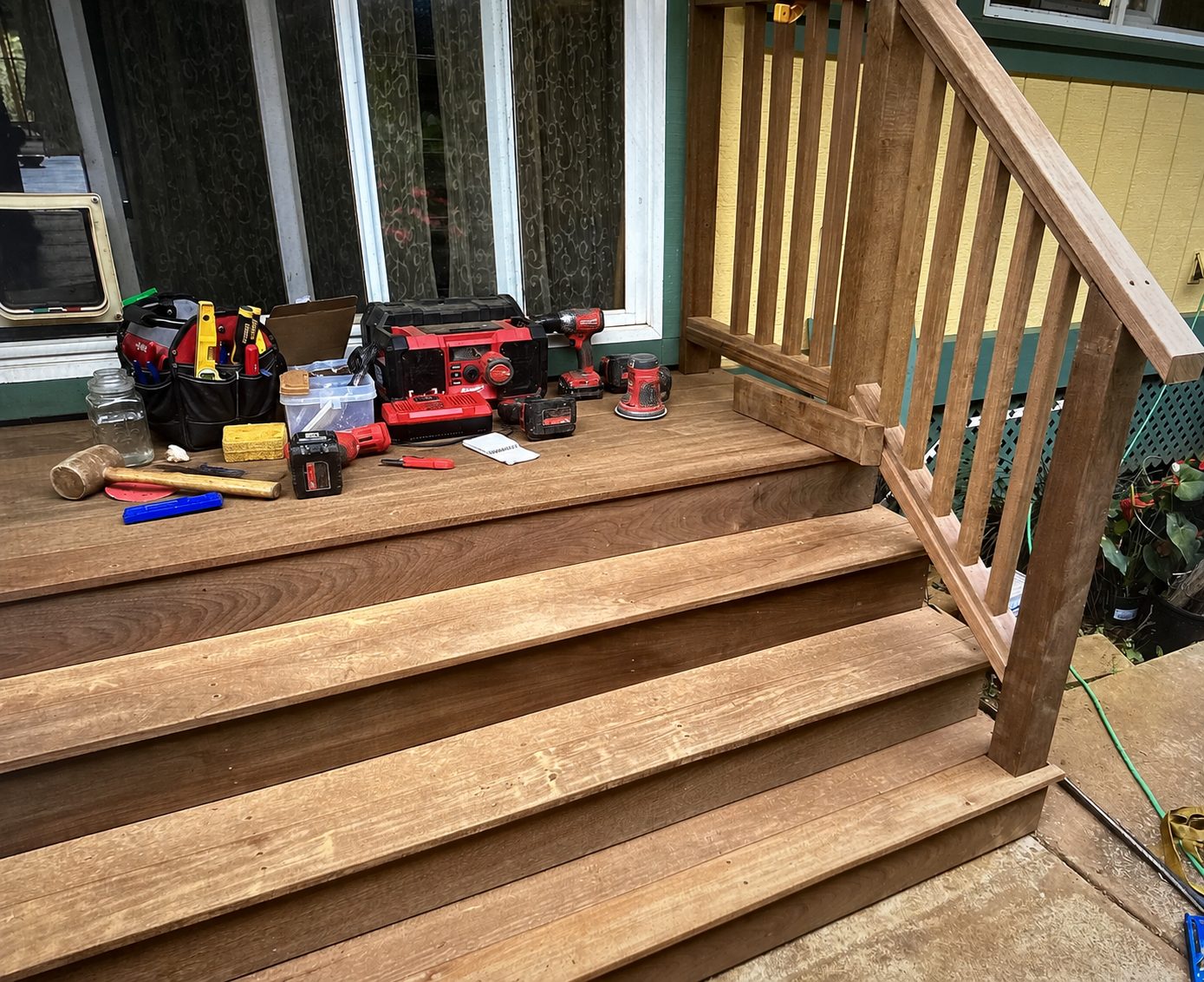 New ipe wood stairs, landing and railing under construction at a home’s entry