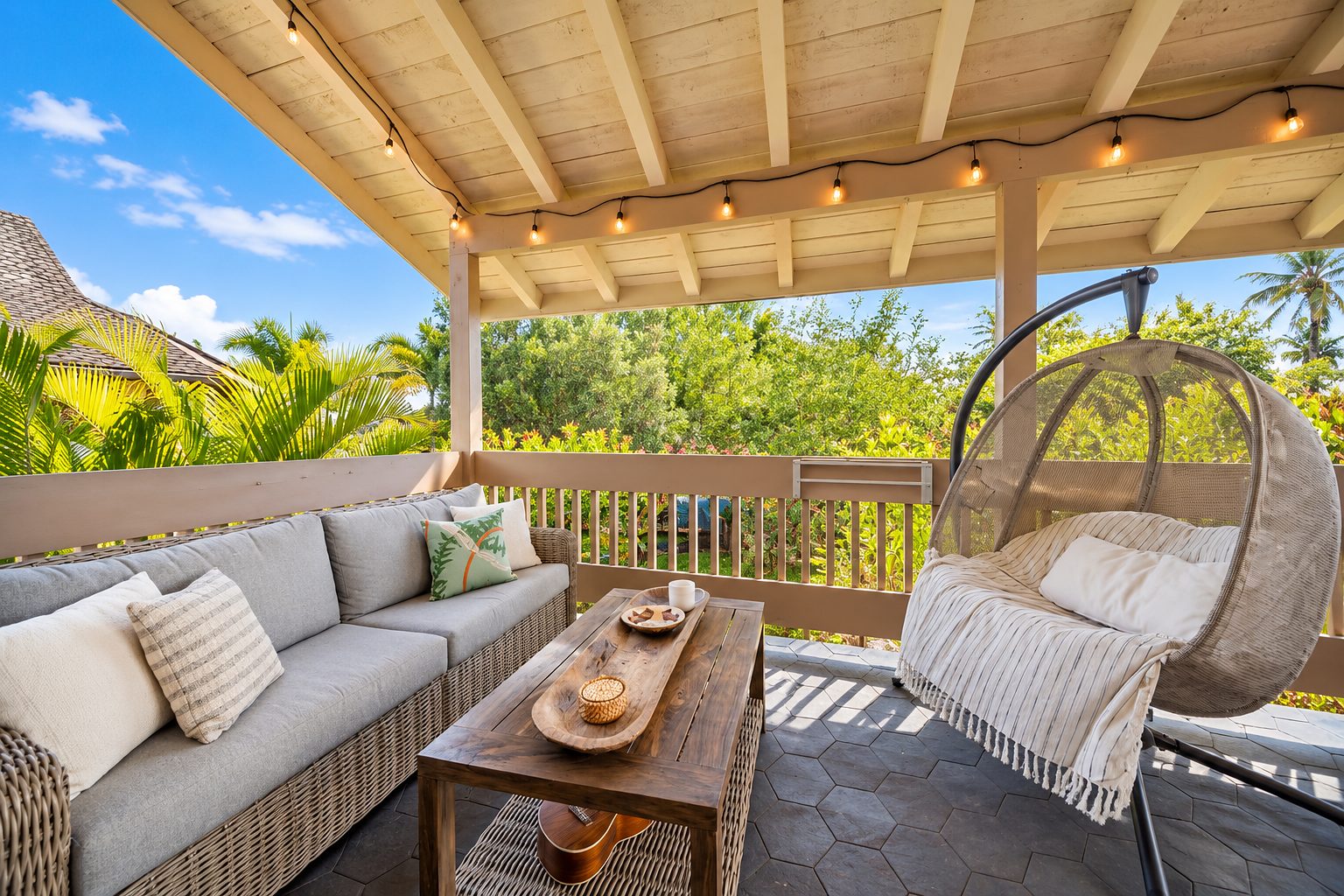 Covered lanai with a hanging chair, wicker sofa and string lights