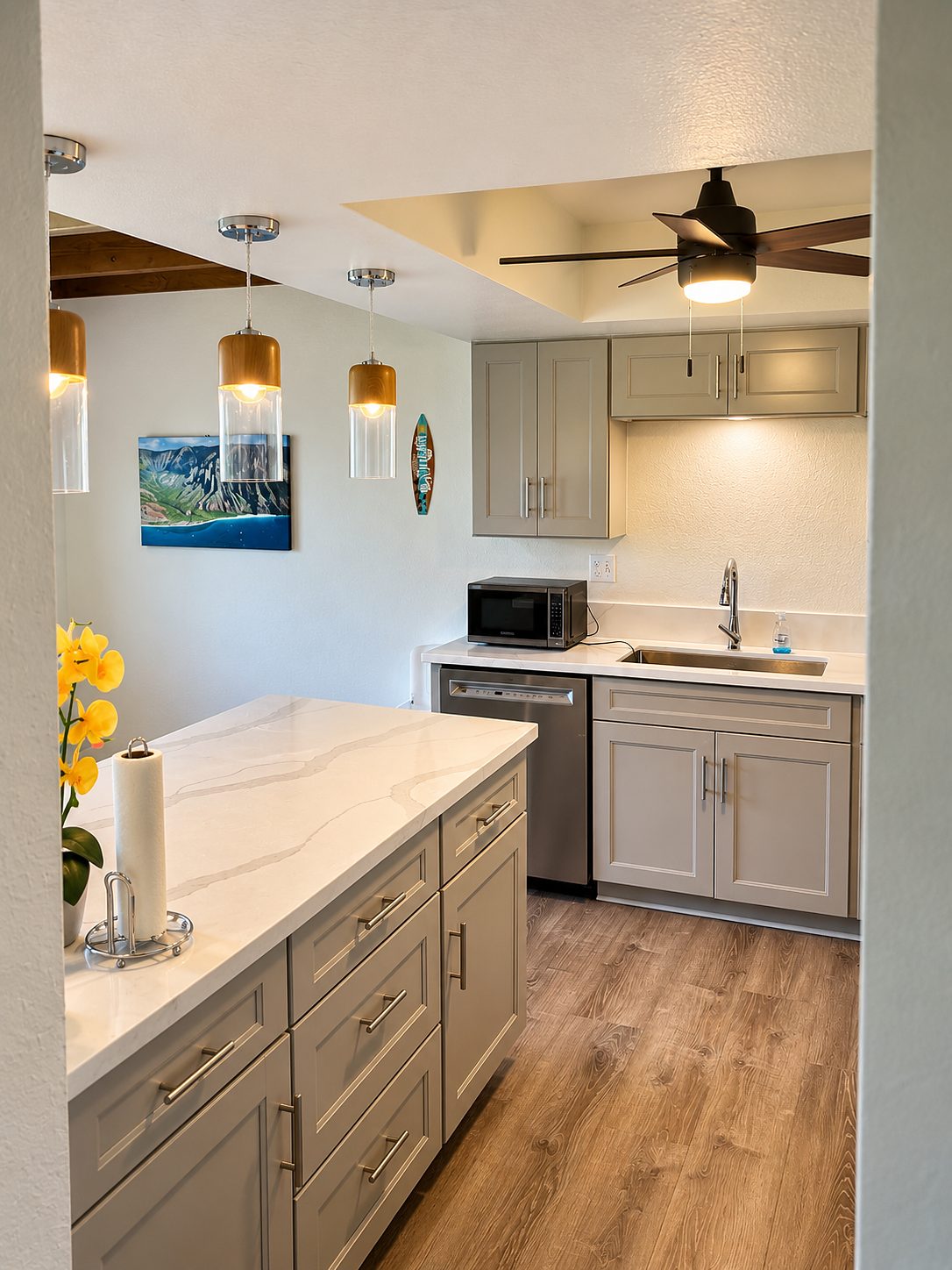 Kitchen with pale grey cabinetry, quartz counters and a window to the garden